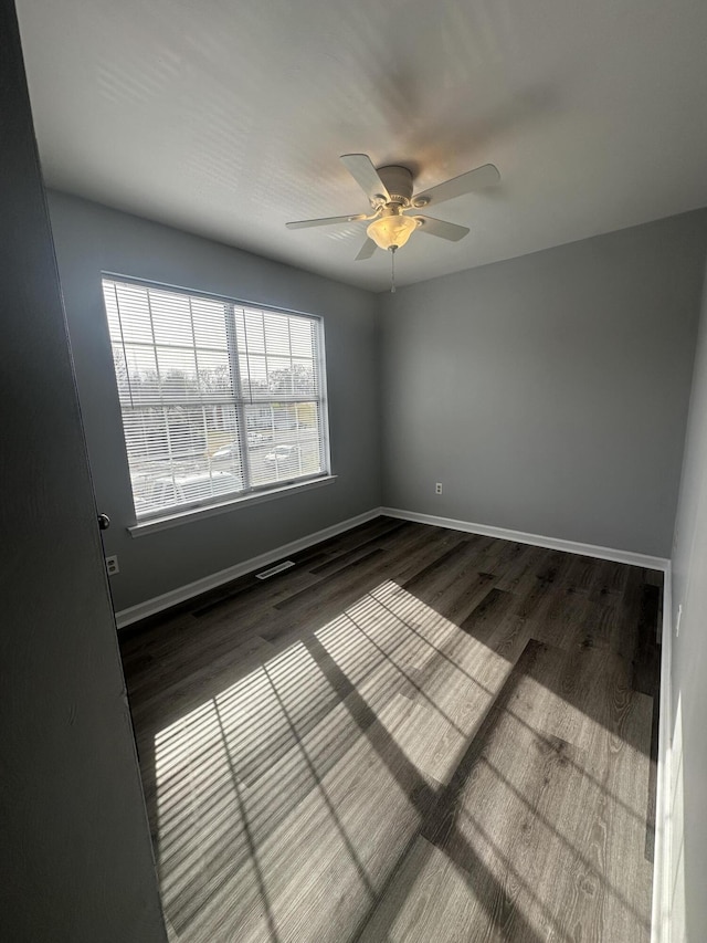 unfurnished room featuring visible vents, baseboards, ceiling fan, and wood finished floors