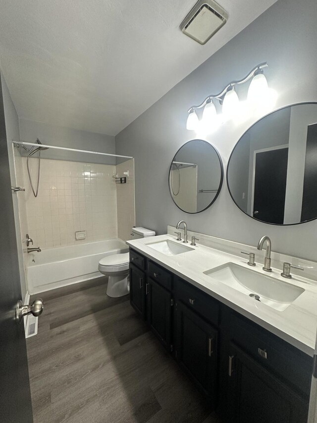 full bathroom with visible vents, a sink, toilet, and wood finished floors