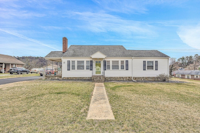 view of front of house featuring a carport, a front lawn, a chimney, and a shingled roof