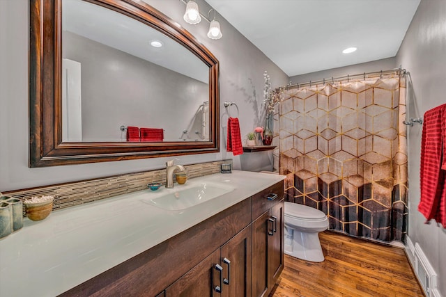 full bath with toilet, a shower with curtain, wood finished floors, and vanity