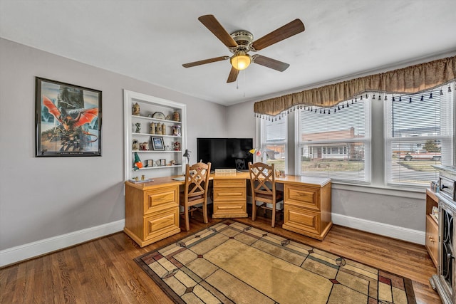 office with built in features, ceiling fan, baseboards, and wood finished floors