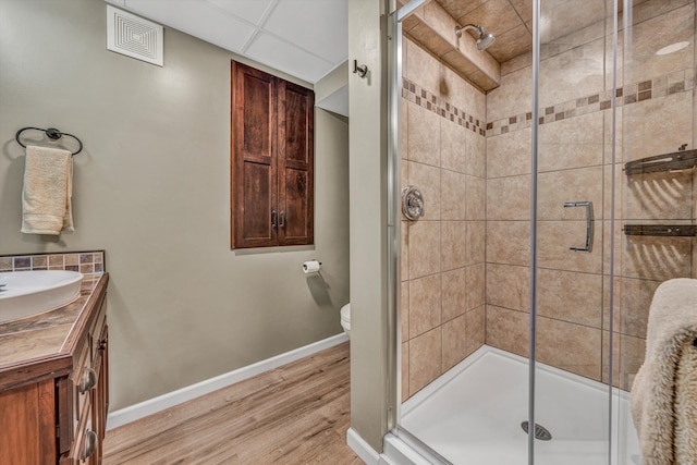 full bathroom featuring toilet, wood finished floors, visible vents, baseboards, and a stall shower