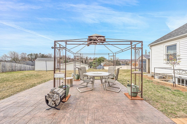 view of patio / terrace with a storage shed, a fenced backyard, an outdoor structure, and outdoor dining space