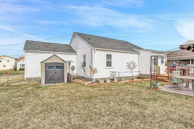 back of property with a hot tub, a lawn, an outbuilding, a deck, and a shed