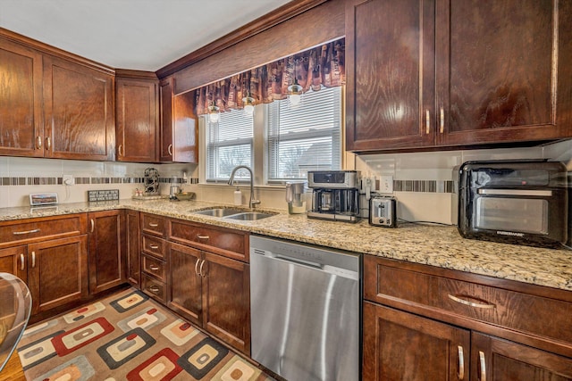 kitchen featuring light stone counters, a toaster, a sink, and stainless steel dishwasher