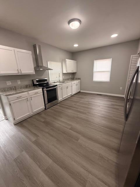 kitchen featuring baseboards, white cabinets, wall chimney exhaust hood, dark wood-type flooring, and stainless steel electric stove