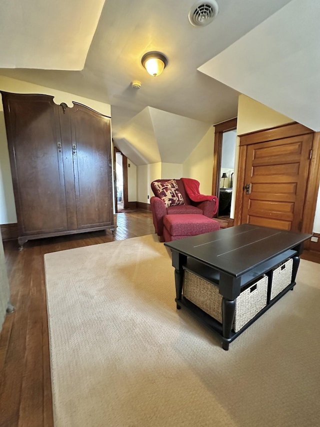 recreation room with visible vents, vaulted ceiling, baseboards, and wood finished floors