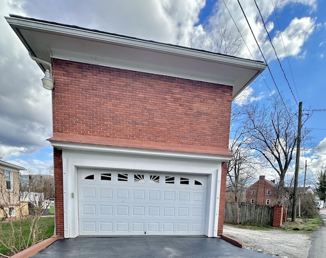 garage with driveway and fence