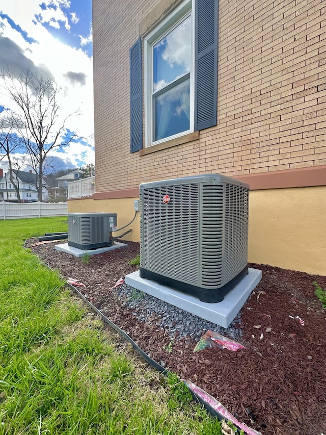 details featuring cooling unit and brick siding