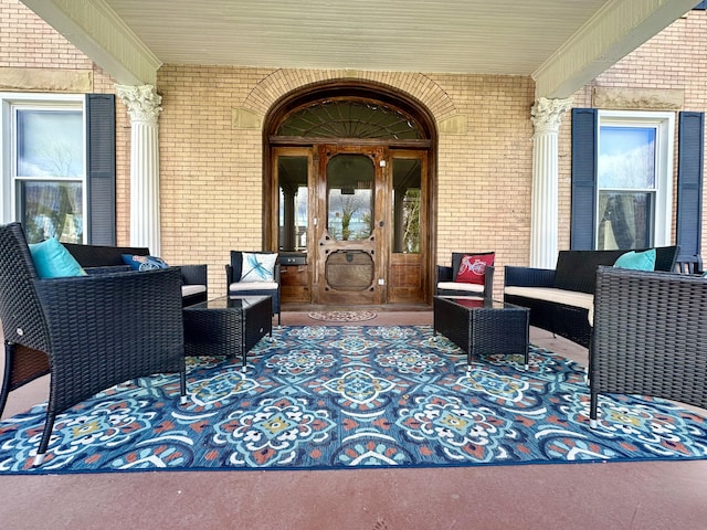 entrance to property with a porch and brick siding