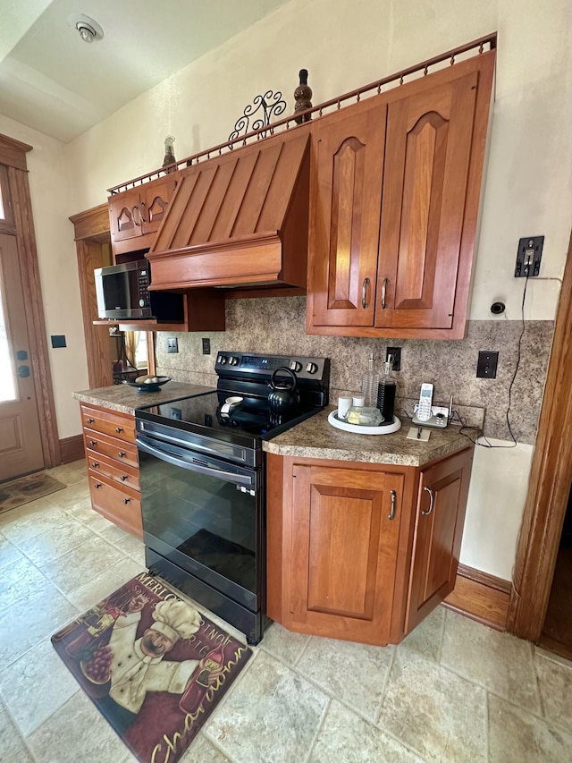 kitchen with brown cabinetry, stainless steel microwave, electric range, and custom exhaust hood