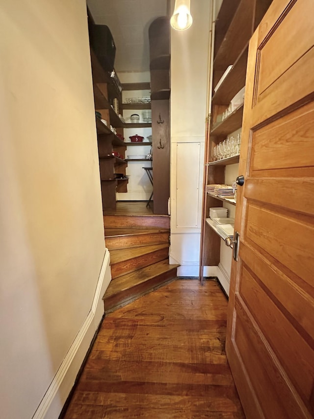 interior space featuring dark wood-style floors, stairway, and baseboards