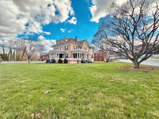 back of house featuring a yard, fence, a chimney, and a deck