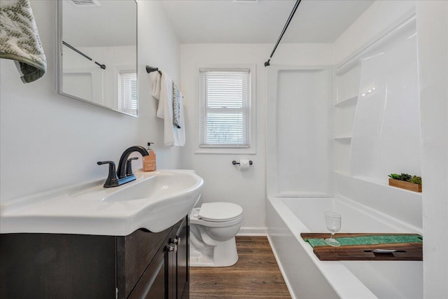 bathroom featuring tub / shower combination, baseboards, toilet, wood finished floors, and vanity