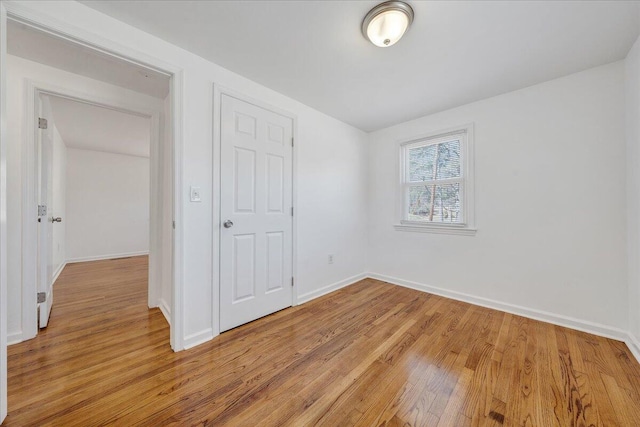 unfurnished bedroom with light wood-type flooring and baseboards