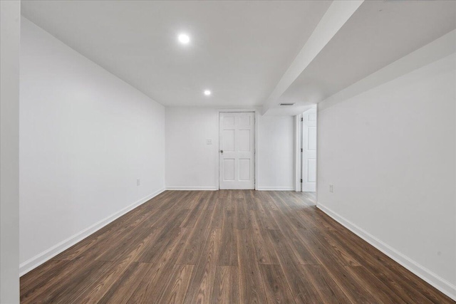 spare room featuring recessed lighting, baseboards, and dark wood-style flooring