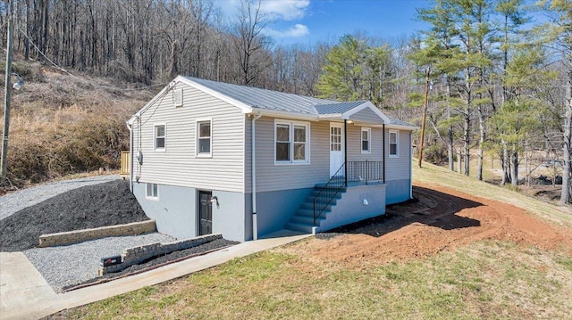 ranch-style home with metal roof and a front lawn