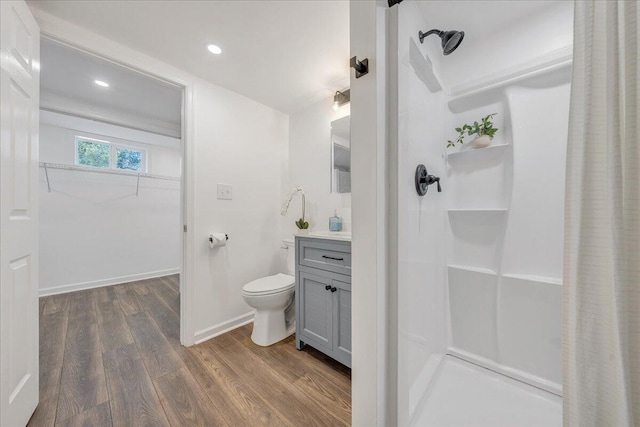 full bath with baseboards, toilet, a shower with shower curtain, wood finished floors, and vanity