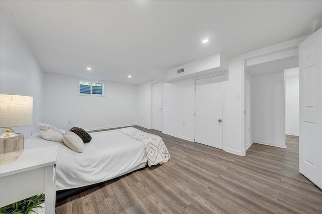 bedroom with recessed lighting, wood finished floors, visible vents, and baseboards