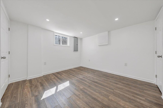 below grade area with electric panel, recessed lighting, baseboards, and wood finished floors