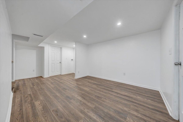 finished below grade area with recessed lighting, visible vents, baseboards, and dark wood finished floors