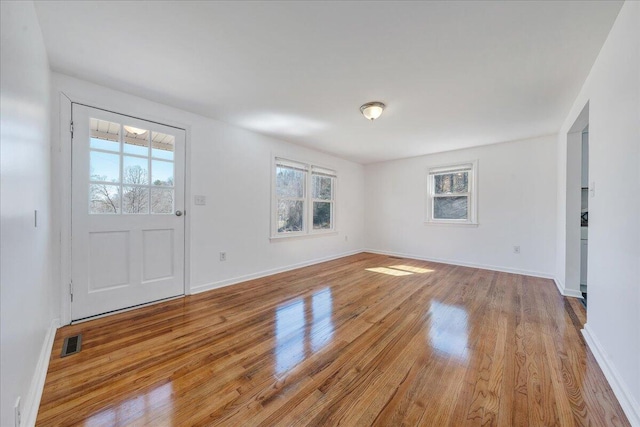 entrance foyer with wood finished floors, visible vents, and baseboards