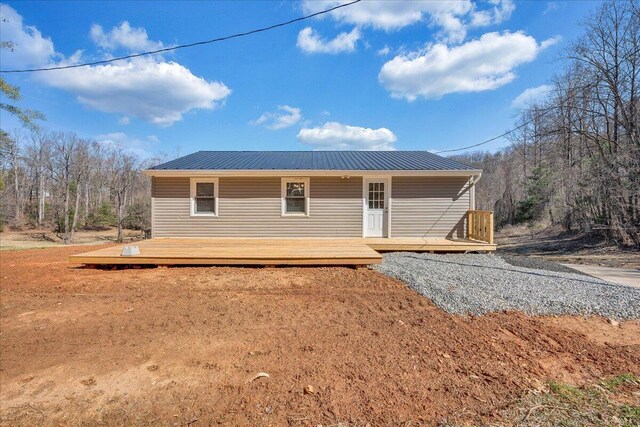 back of property with a deck and metal roof