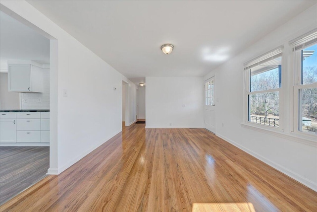 spare room featuring baseboards and light wood finished floors