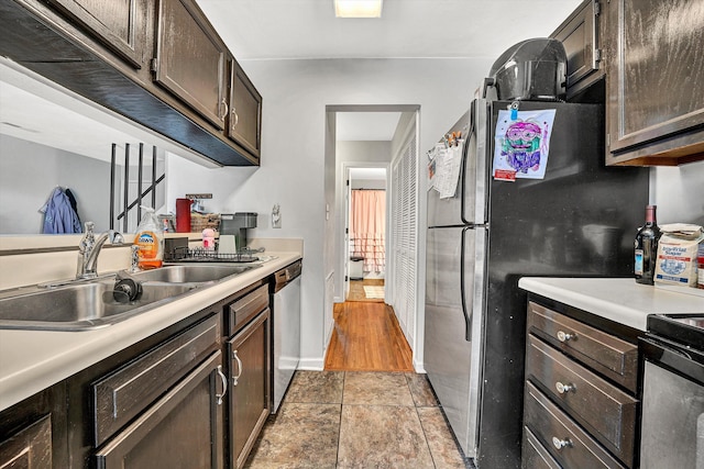 kitchen featuring light countertops, dark brown cabinets, appliances with stainless steel finishes, and a sink