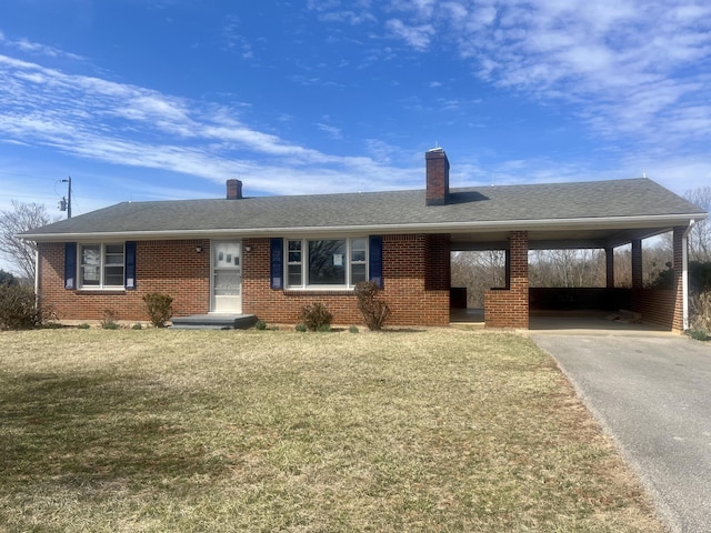 single story home featuring roof with shingles, brick siding, a front yard, an attached carport, and driveway