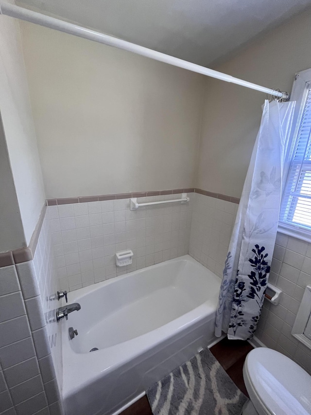 full bathroom with toilet and tile walls