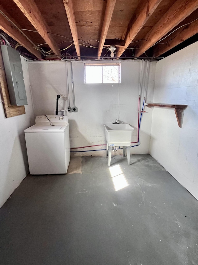 below grade area featuring washer / dryer, electric panel, and a sink