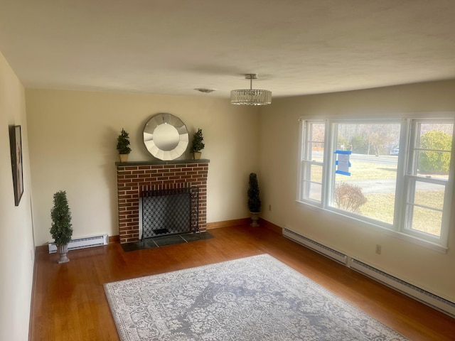 unfurnished living room with a fireplace, baseboards, baseboard heating, and wood finished floors