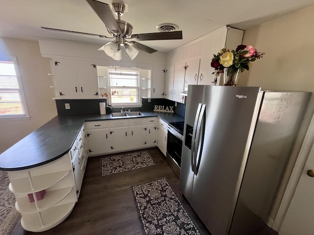 kitchen featuring visible vents, dark countertops, stainless steel appliances, open shelves, and a sink