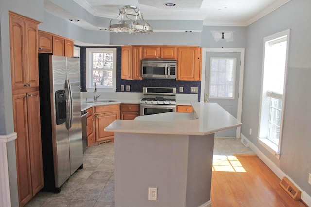 kitchen with visible vents, stainless steel appliances, crown molding, light countertops, and a sink