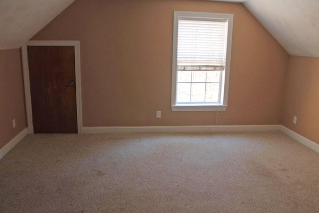 additional living space featuring carpet flooring, vaulted ceiling, and baseboards