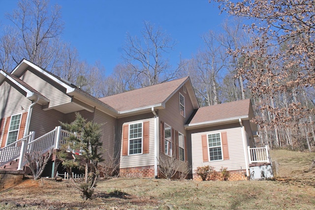 view of home's exterior featuring a shingled roof and a yard