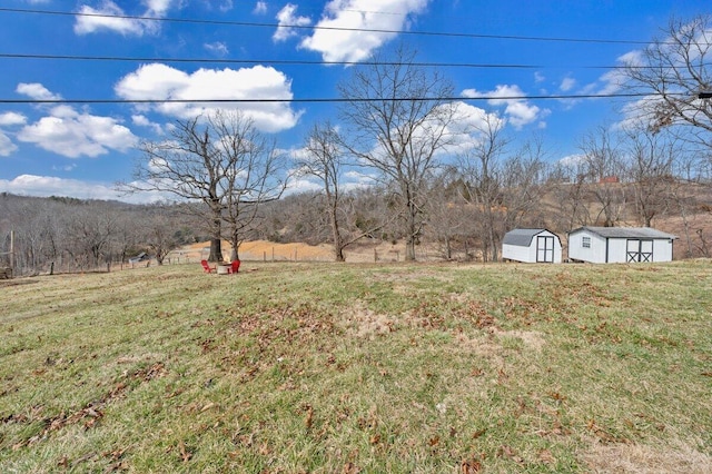 view of yard with a rural view, an outdoor structure, and a shed