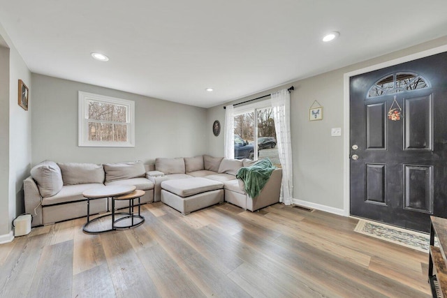 living area with baseboards, recessed lighting, visible vents, and light wood-style floors