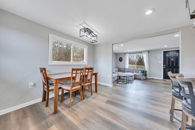 dining room with baseboards, wood finished floors, and recessed lighting