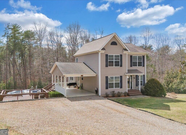 view of front facade featuring driveway, a front lawn, and a shingled roof