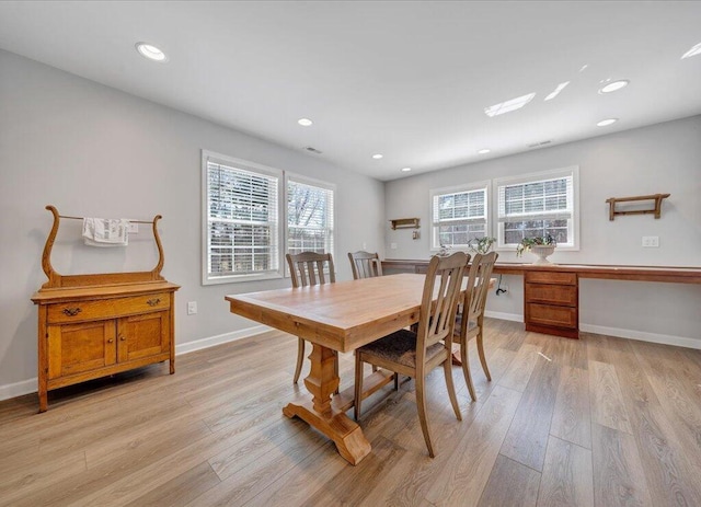 dining area with light wood-type flooring, baseboards, built in desk, and recessed lighting