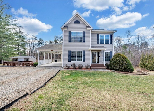 view of front of property with an attached carport, driveway, and a front lawn