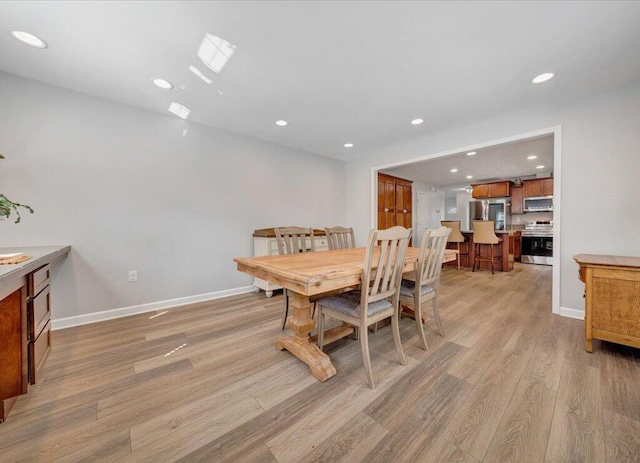 dining area featuring recessed lighting, baseboards, and light wood finished floors