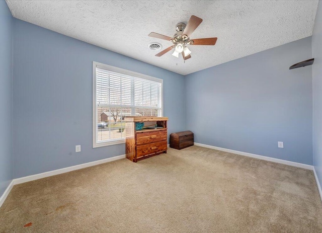 unfurnished room with a ceiling fan, carpet, visible vents, and baseboards