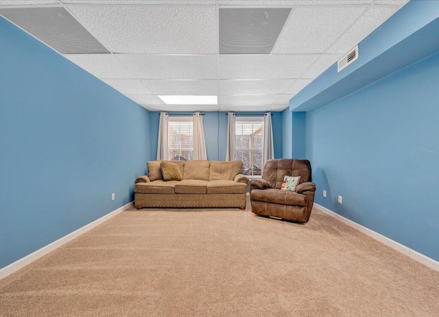 living room featuring visible vents, carpet floors, a paneled ceiling, and baseboards