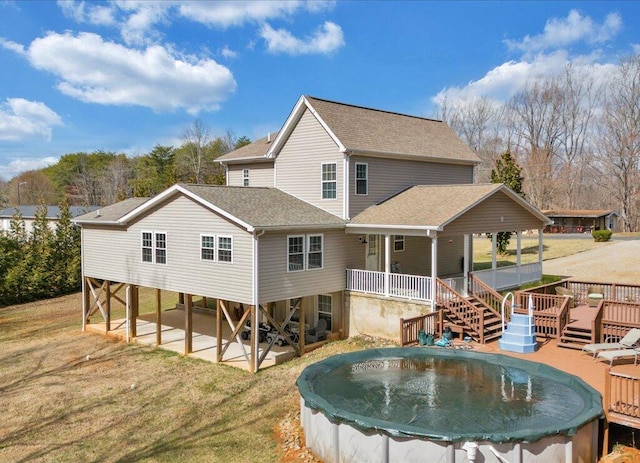 back of property with a patio, stairs, a yard, roof with shingles, and a covered pool