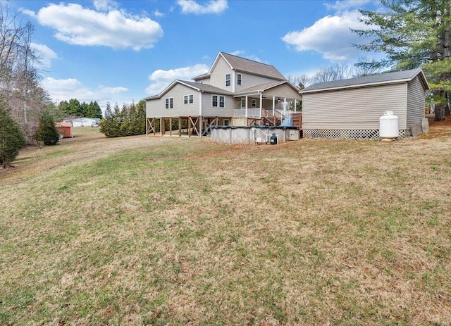 rear view of property with a yard and a wooden deck