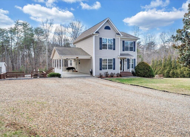 view of front of home with a front yard and gravel driveway