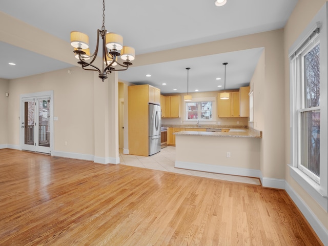 kitchen featuring recessed lighting, light wood-style floors, a peninsula, and freestanding refrigerator